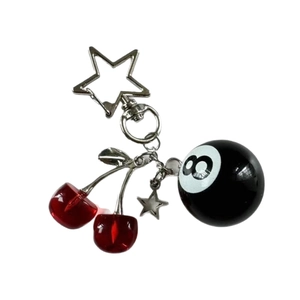Handmade red cherry metal keychain with black 8-ball and star pendants on white background