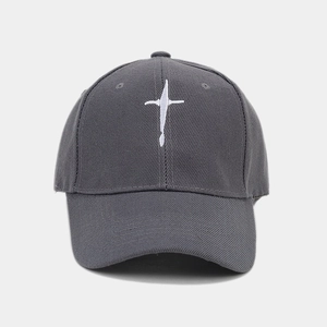 Détail macro de la casquette gris foncé avec broderie étoile blanche et texture en coton