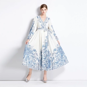 V-neck long sleeve white maxi dress featuring blue floral prints and a waist tie