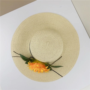 Vue de dessus d'un chapeau de paille à large bord avec une fleur de tournesol