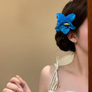 Vista dettagliata di un fermaglio per capelli a forma di fiore blu vibrante su una modella