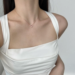 Close-up of rose gold hollow heart pendant necklace with cubic zirconia on model