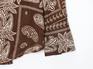 Detailed close-up of brown paisley printed fabric showing high-quality woven texture
