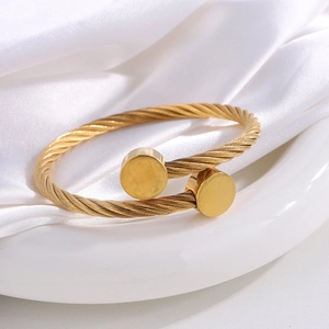 Minimalist gold-plated twisted cable cuff bracelet with polished round ends on silk