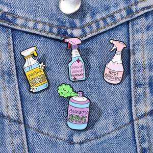 Detailed close-up of colorful spray can enamel pins on a classic blue denim jacket