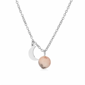 Gros plan d'un pendentif lune argenté avec une pierre naturelle rose sur une chaîne