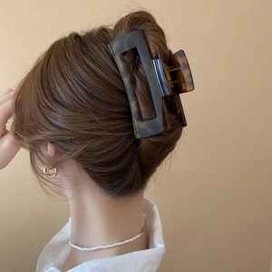 Detail of a large tortoiseshell claw clip securing a classic French hair twist