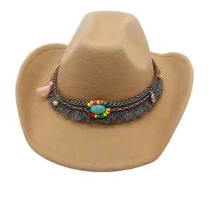 Detail of khaki cowboy hat featuring ethnic beaded band, turquoise stone, and pink tassel