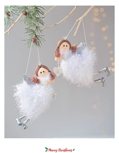 Detail view of plush Christmas angel hanging ornaments with silver wings on pine branch