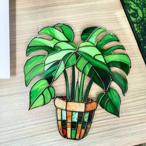 Close-up of Monstera leaf suncatcher in stained glass style with mosaic pot detail