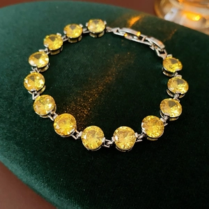 Close-up of a royal style round yellow zircon bracelet on a dark green velvet background