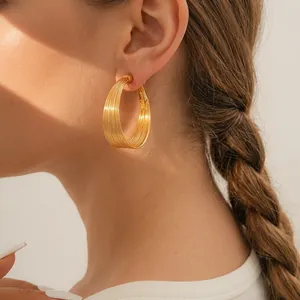 Minimalist gold multi-layer hoop earrings shown on model for a sophisticated layered look