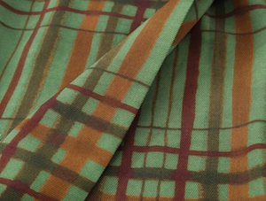 Detail of green and brown plaid fabric texture with twill weave and elegant soft folds