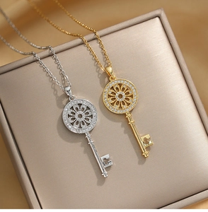 Detail of gold and silver key pendants with cubic zirconia on metallic jewelry box
