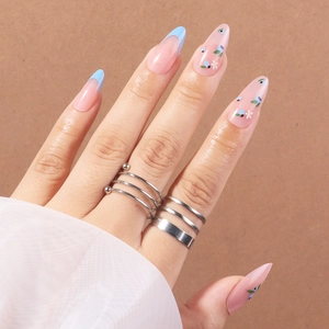 Faux ongles amande avec base rose, French tips bleu clair et motifs de bleuets fleuris