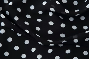 Macro shot of polka dot chiffon fabric showing the delicate texture and sheer drape