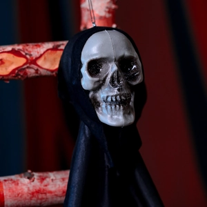 Close-up of a scary Halloween skull hanging ghost with black hooded robe and dark background