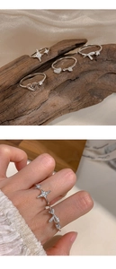 Macro shot of S925 silver ring featuring heart and bow designs with sparkling zircons