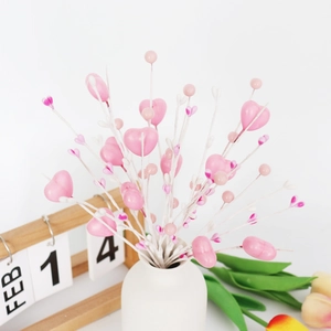 Détail de tiges de baies roses en forme de cœur dans un vase pour la Saint-Valentin