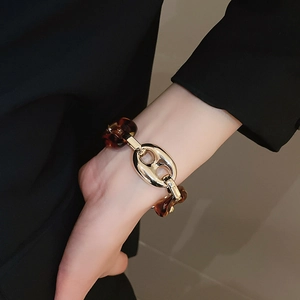 Dettaglio del bracciale a maglie con stampa leopardata e metallo dorato sul polso