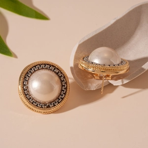 Detail of vintage round stud earrings featuring faux pearl with gold and silver chain edge