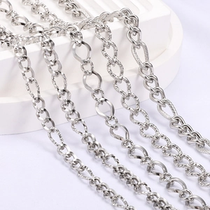 Polished silver stainless steel link chain variety set on white geometric display stands