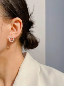 Close-up of elegant gold wreath stud earrings with white pearls and clear crystals