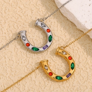 Detail of horseshoe pendants in gold and silver finish with colorful inset crystals
