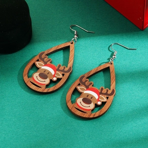 Detail of wooden drop earrings with reindeer and Santa hat on a festive green background