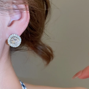 Close-up of elegant silver stud earring with sparkling round zircon and halo design