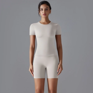 Détail d'un ensemble de yoga beige clair en nylon avec haut à manches courtes et short ajusté