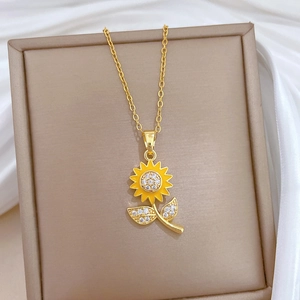 Golden sunflower necklace with yellow petals and sparkling crystals on white silk background