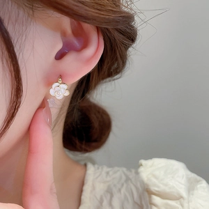 Elegant pearl flower gold plated geometric hoop earrings on female model's ear