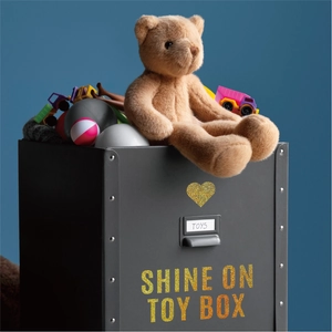 Detail of black toy box with gold glitter heart and Shine On lettering for storage