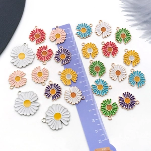Detail view of colorful daisy flower alloy pendants for DIY jewelry making with purple ruler