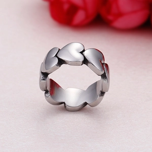 Polished silver heart eternity ring with continuous heart design on pink background