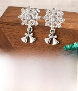 Detail view of snowflake zircon pendant earring with pearl element and bell charms