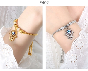 Detailed close-up of Fatima hand and evil eye charms on 18K gold and silver beaded bracelets
