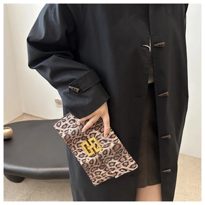 Detail of the leopard print envelope clutch featuring a square gold metal lock closure