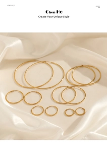 Detailed view of six pairs of gold hoop earrings in varying sizes on white silk fabric