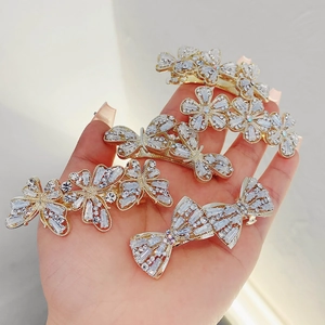 Five-piece set of golden metal hair clips with bow, flower designs and rhinestones