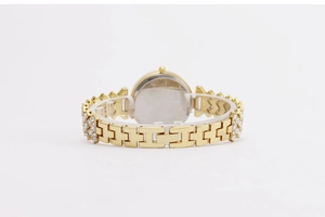Detail view of the silver metal case back and crystal-encrusted gold chain watch strap