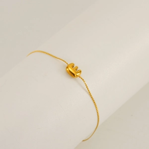 Minimalist gold chain bracelet featuring a letter E pendant for a stylish jewelry look
