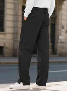 Rear view of black waffle knit pants showing geometric texture and straight fit