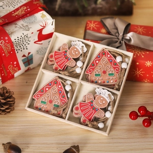 Close-up of wooden gingerbread man and house ornaments in a four-grid storage tray