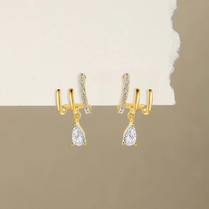 Detailed macro of gold S925 sterling silver triple-layer earrings with teardrop zircons