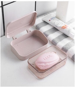 Pink double-layer soap box with drainage tray in a modern bathroom setting