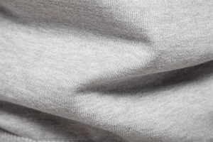 Vue macro du tissu en maille de coton gris montrant les fibres et le tissage doux