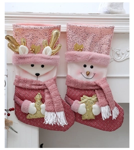 Detail von rosa Pailletten-Weihnachtssocken mit Rentier- und Schneemann-Plüschfiguren