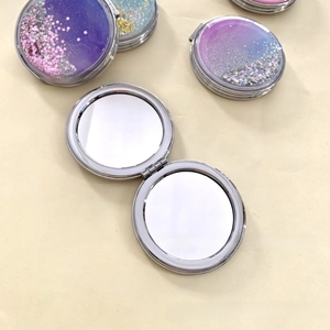 Detail of a portable round folding makeup mirror with sparkling glitter quicksand lid